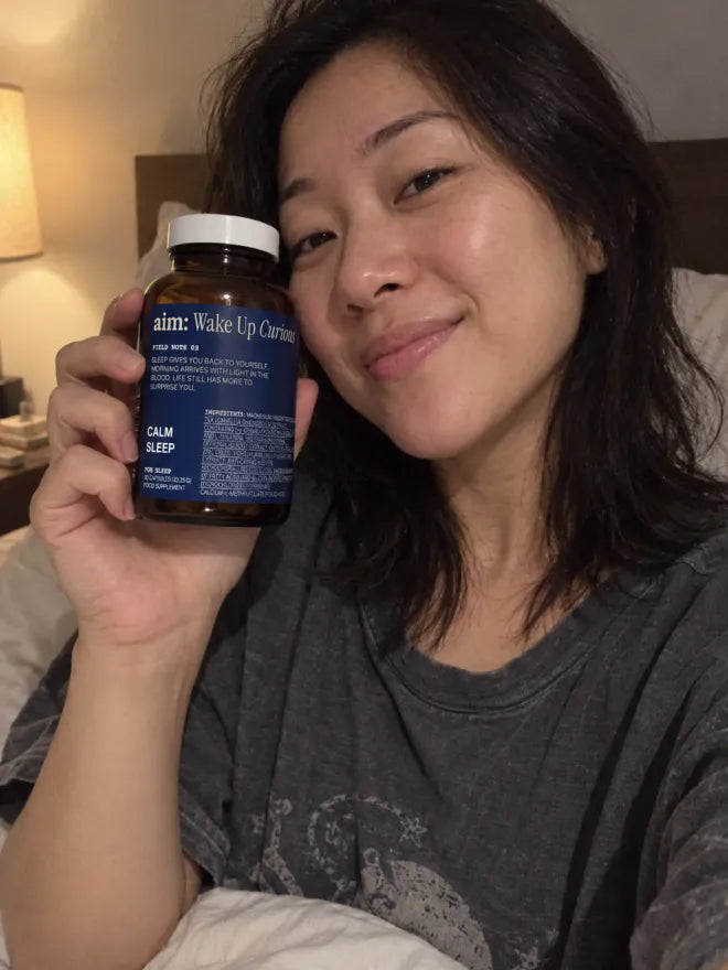 Someone at home holding a bottle of AIM Calm Sleep