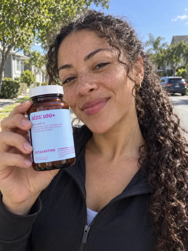 Someone outdoors holding a bottle of AIM Gut Balance