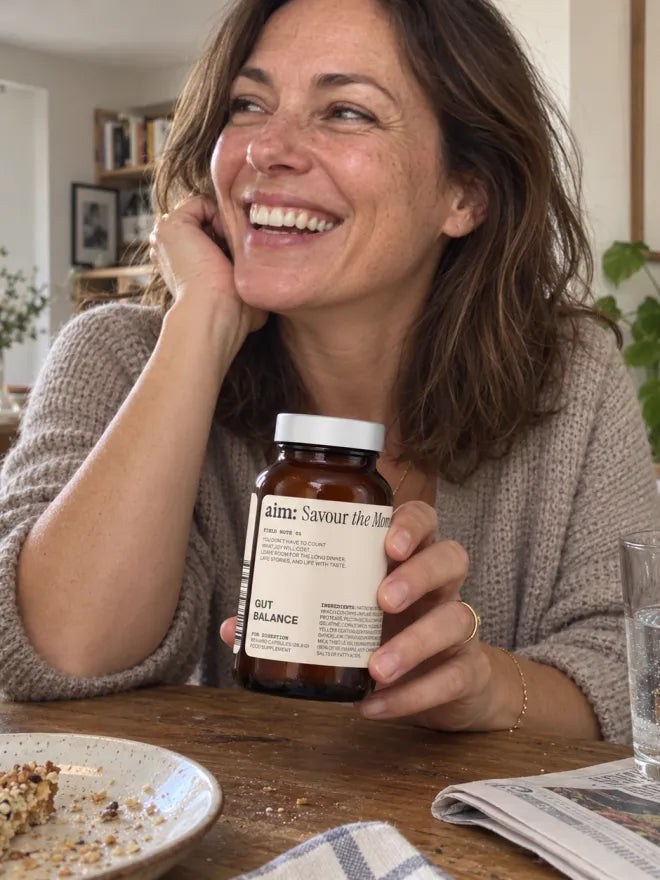 Someone at a breakfast table with a bottle of AIM Gut Balance